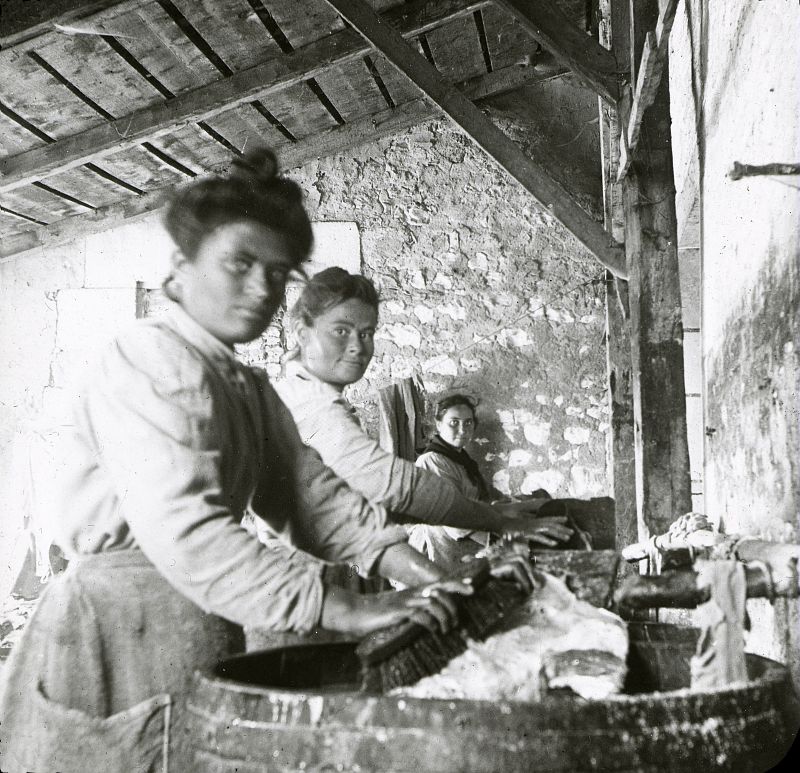 Lavage des filets de morue, atelier avec trois femmes qui brossent les morues au dessus de baquets.